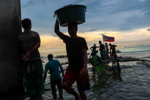 Workers haul their catch of clams and mussels in the late afternoon at the Navotas fish port in Manila on Tuesday. President Duterte is set to discuss rights and access of Filipino fishermen to the disputed West Philippine Sea during his visit to China on October 19-21.(MNS photo) 