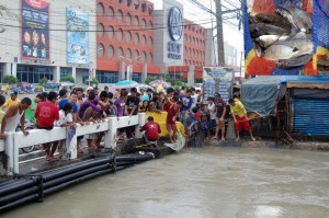 Residents catch tilapia at Panapaan Bridge, Barangay Habay I in Bacoor, Cavite on Thursday (August 22, 2013) as heavy flooding persists in Metro Manila and nearby provinces due to the enhanced southwest monsoon. (MNS photo)