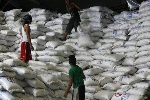 A worker passes a sack of rice to other workers inside a National Food Authority (NFA) warehouse in Taguig City, south of Manila March 26, 2012. The Philippines is close to signing a government-to-government rice supply agreement that would make Cambodia a potential supplier of the grain staple to Manila, along with Vietnam and Thailand, agriculture officials said on Monday. REUTERS/Cheryl Ravelo (PHILIPPINES - Tags: AGRICULTURE BUSINESS POLITICS)