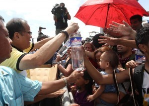 President Benigno S. Aquino III personally distributes water to the families displaced by Super Typhoon Yolanda (Hainan) at the evacuation center during his visit to the province of Leyte to assess the extent of damage in the area on Sunday (November 10). Typhoon Yolanda is the world's most poerful typhoon in 2013. (MNS photo)