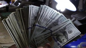 A money changer inspects U.S. dollar bills at a currency exchange in Manila January 15, 2014. (MNS photo)