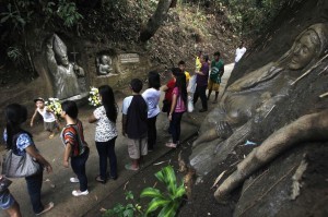 Visitors look at an image of Pope John Paul II carved opposite an image of the Virgin Mary (R) on a hillside in Maragundon town, Cavite city, south of Manila April 26, 2014. Sculptors Val and his brother Oca Suarez, finished sculpting of image of Pope John Paul II in two days. . Pope John XXIII, who reigned from 1958 to 1963 and called the modernizing Second Vatican Council, and Pope John Paul II, who reigned for nearly 27 years before his death in 2005 and whose trips around the world made him the most visible pope in history, will be declared saints by Pope Francis at an unprecedented twin canonization on Sunday. (MNS photo)