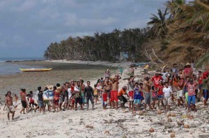 Typhoon victims wait for relief supplies on a beach in a remote village in Dolores, Eastern Samar on Tuesday. Typhoon Ruby barreled across central Philippines and devastated remote villages making it hard for government response teams to reach the areas.(MNS photo)