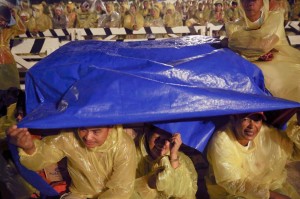 Pilgrims brave rain and strong wind as they wait at Tacloban airport for Pope Francis to arrive on Saturday. About two million people are expected to attend an open-air mass in Leyte, which is still struggling to recover from Super Typhoon Yolanda that killed more than 6,000 people in 2013. (MNS photo)