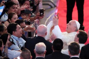 Pope Francis puts a crown on an image of the Virgin Mary presented to him by someone from the crowd during the Encounter with Families at the MOA Arena on Friday. A chosen crowd of about 20,000 watched and listened as the Pope reflected on the family's importance. (MNS photo)