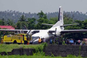 People gather near a Philippine Air Force (PAF) Fokker F27 plane that nosedived on the runway of Legazpi City airport on Monday. No one was hurt in the mishap caused by the nose landing gear of the plane that failed, but the accident caused flight delays at the airport.(MNS photo)